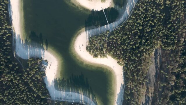 Top down aerial drone shot of Henschotermeer lake, tropical paradise lake with a small island in the middle. White sandy beaches in nature, Beautiful outdoor adventure scenery 4K.