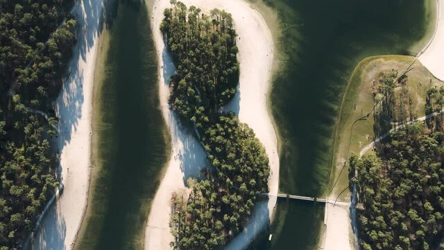 Top down aerial drone shot of Henschotermeer lake, tropical paradise lake with a small island in the middle. White sandy beaches in nature, beautiful outdoor swimming location.