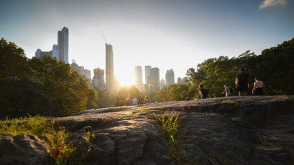 Sunset in Central Park. Some people are enjoying the beautiful view of the sunset in this part of...