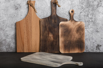 Samples of various wooden cutting boards on a kitchen countertop. Production of household goods