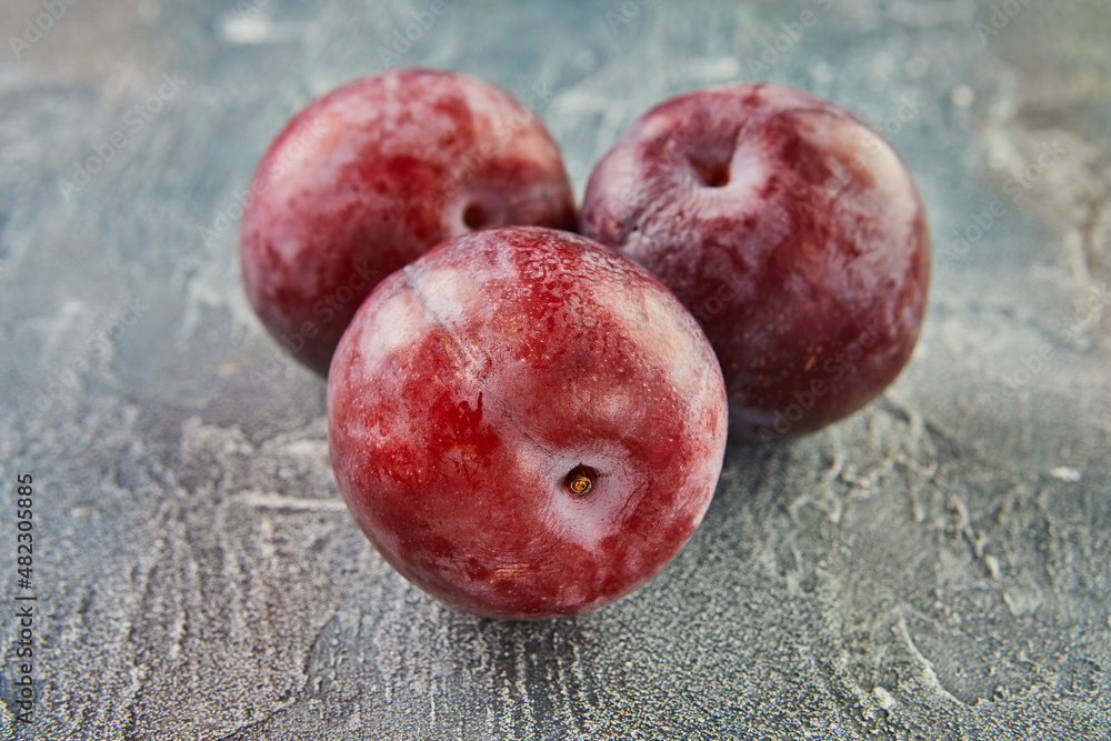 Sticker Fresh plums on a blue background. background of beautiful home plums