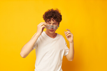 Young curly-haired man in blue glasses white t-shirt fashion modern style isolated background unaltered