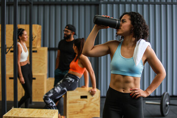 Woman drinking water after gym workout