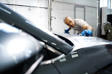 African American man car service worker applying nano coating on a car