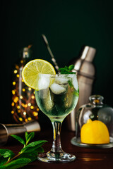 Fresh Mojito cocktail with lemon, mint and ice in jar glass on dark blue background. Summer cocktail