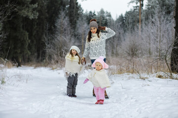 Happy family playing and laughing in winter outdoors in the snow. City park winter day.