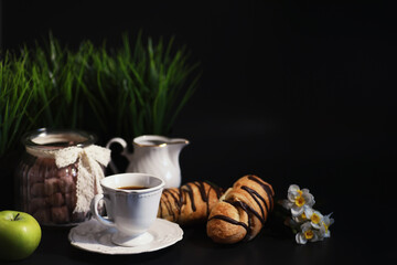 French breakfast on the table. Coffee croissant with chocolate and a decanter with cream. Fresh pastries and decaffeinated coffee.