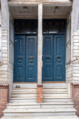 Naklejka na ściany i meble Two twin blue wooden doors with stone staircase and dividing post. Vertical photo.