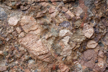 The texture of rock consisting of various small stones. Horizontal image.