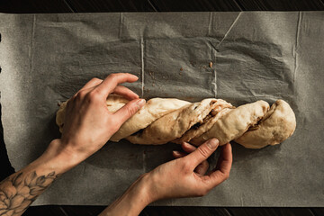 Baking sweet cottage cheese braided bread with raisins and jam. Overhead shot.
