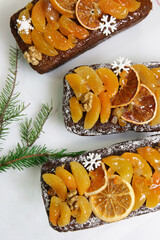 Traditional  Christmas stollen on white background. Dessert is decorated with dried fruits and candied fruits.