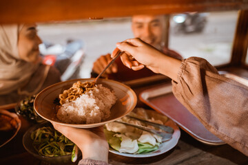 hand taking some food in traditional food stall