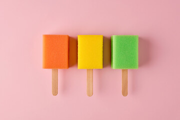 Colorful popsicle ice creams made out of sponge on pastel pink background. Minimalistic creative...