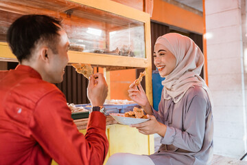 Fototapeta na wymiar muslim couple sitting on traditional food stall, waiting for iftar time