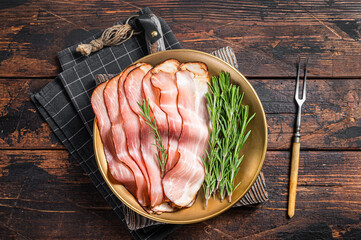 Dry cured pork Black Forest Ham bacon with rosemary. Wooden background. Top view - obrazy, fototapety, plakaty