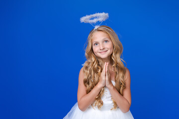 Postcard for valentine's day. Child in long white dress and with angel wings on a blue background....