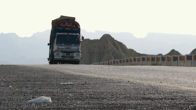Fully Laden Lorry Driving Along Going Past On Makran Coastal Highway In Balochistan. Low Angle Zoom Out
