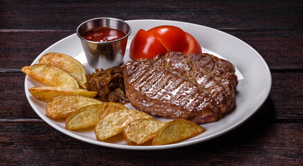 Delicious juicy beef steak with baked potatoes and sauces on a white dish
