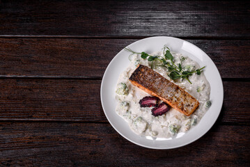 Tasty baked salmon fish on a white dish with broccoli and pea sprouts