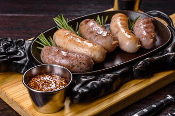 Delicious fresh juicy sausages grill with red sauce in a beautiful cast iron pan