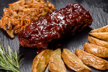 Spicy barbecued pork ribs served with BBQ sauce on chopping board