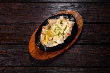 A delicious seafood dish baked with cheese and breadcrumbs in a cast iron bowl