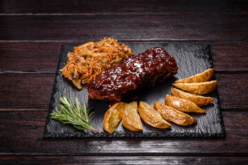 Spicy barbecued pork ribs served with BBQ sauce on chopping board