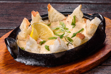 A delicious seafood dish baked with cheese and breadcrumbs in a cast iron bowl