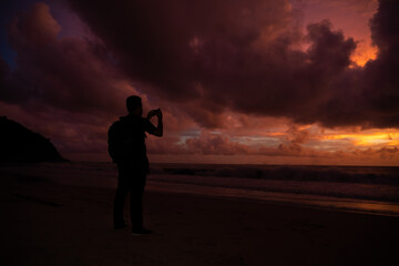 Silhouette of a traveler watching sunset at beach