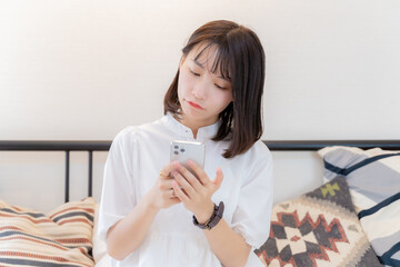 スマホを不満げな表情で見る女性