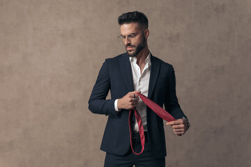 dramatic businessman looking down while holding his tie © Viorel Sima
