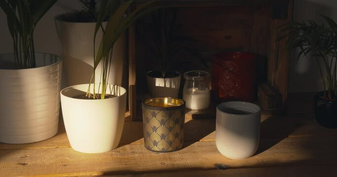 Beautiful home decor with plants and candles on cupboard in dim light. Dolly right