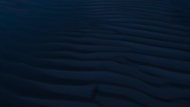 Aerial, sand dune ridge patterns on dark night