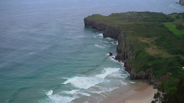 Calm Waves Crashing On Pandon Point Cliffs At Ballota Beach, Spain