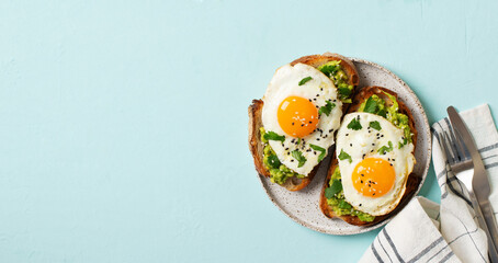 Healthy breakfast with eggs toast and orange juice on blue background