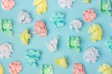 Pattern made with colored crumpled paper balls on blue background, texture. Top view Flat lay