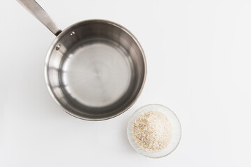Rice in bowl and stew pot on white background.
