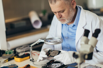 Engineer fixing broken computer hard drive. Electronic repair shop, technology development concept