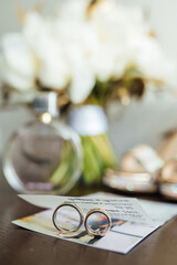 beautiful gold wedding rings on wooden table next to bouquet and shoes