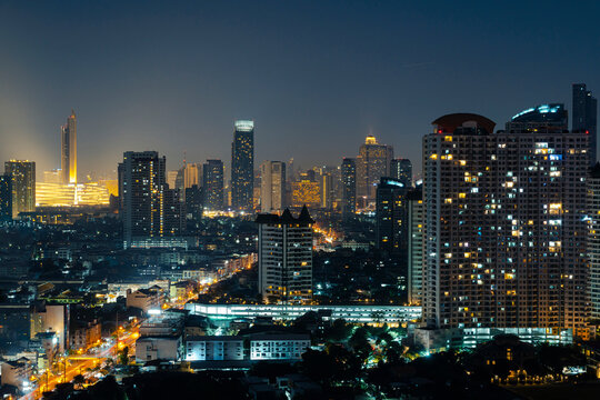 Modern cityscape with illuminated buildings at night, Bangkok, Thailand