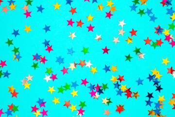 Multicolored stars on a blue paper background. Festive background.