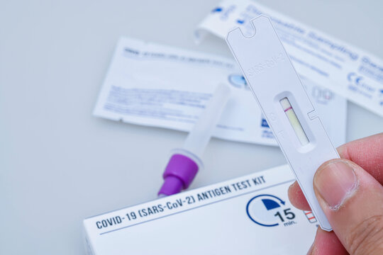 Hand holding Covid-19 negative test result with SARS-CoV-2 Rapid antigen test kit (ATK).Self testing for Coronavirus infectious protective.