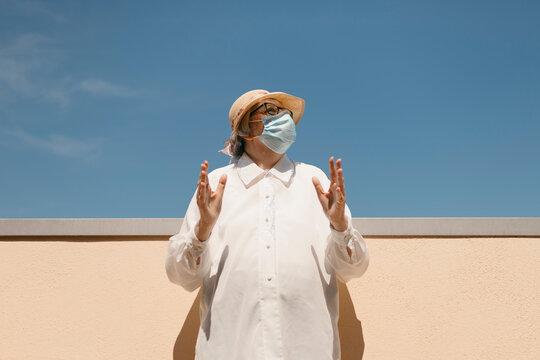 Senior woman wearing protective face mask on sunny day