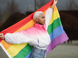 Confident LGBTQIA woman holding rainbow flag