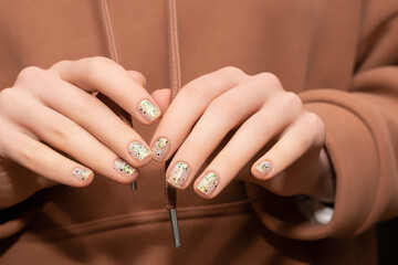 Female model hands with clear nail design. Glitter clear nail polish manicure with green nail art....