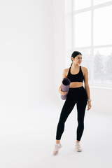 Fototapeta premium Fit woman with a gym mat isolated over white backgound