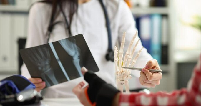 Doctor and patient are examining an x-ray with hand injury