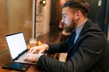 Freelancer using laptop typing at restaurant