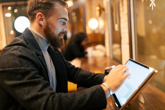 Freelancer using touch screen laptop at restaurant