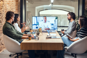 Businesswoman explaining businessman on video call in meeting at creative office